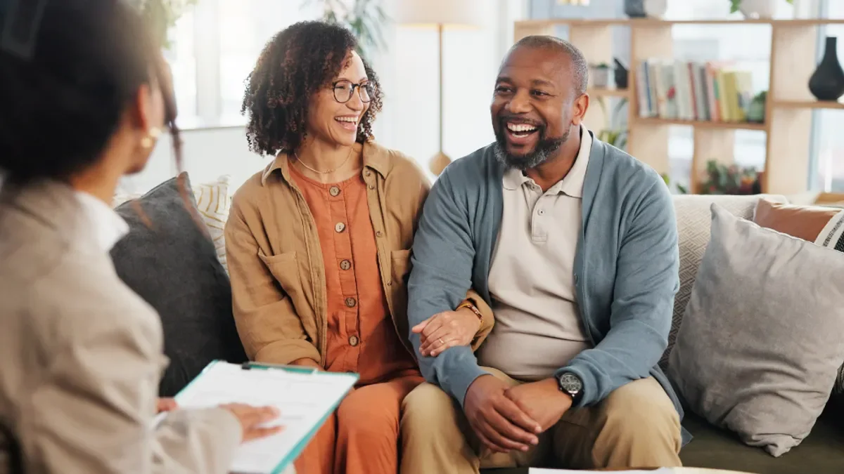 Three people in a discussion in a bright, cozy living room