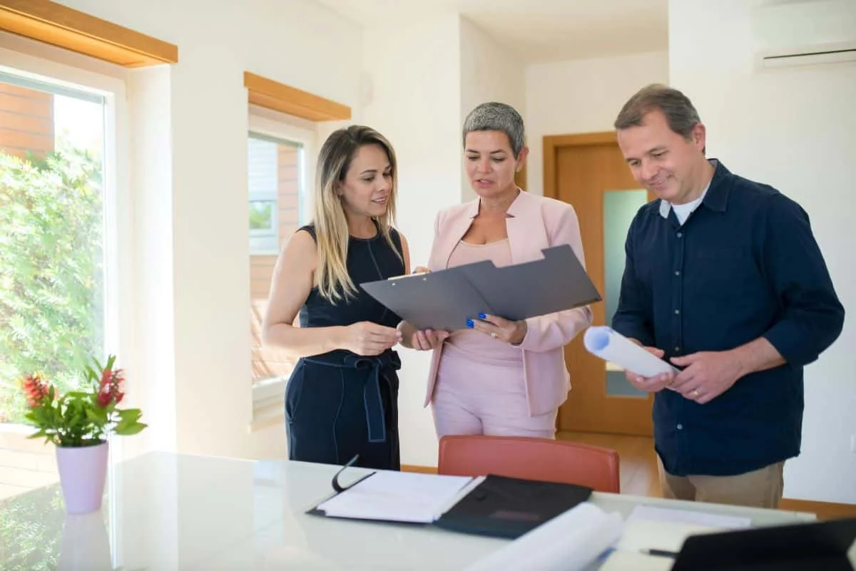 People standing around looking at documents illustrating how to negotiate on house price