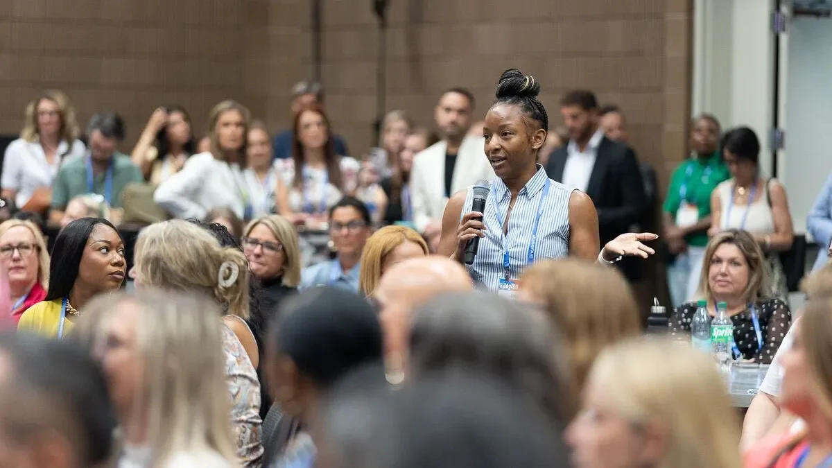 An attendee speaks into a microphone at a conference