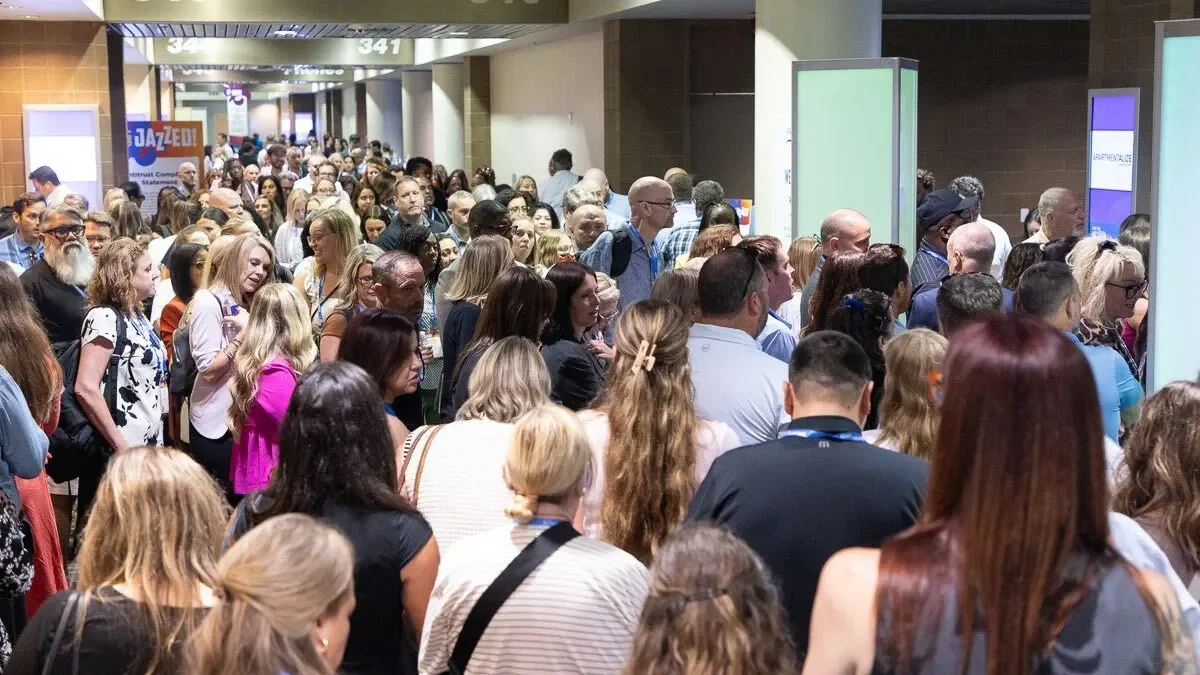 Attendees crowd into the entrance of a room at a conference
