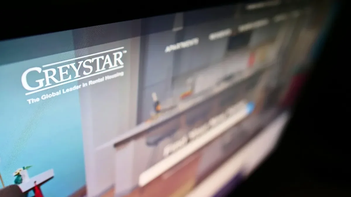 A high-angle view of the business website with the logo of the US apartment company Greystar Real Estate Partners LLC on the monitor.