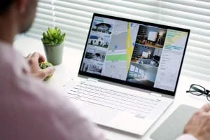 A person looking at an online home searching platform, shopping for homes on their computer