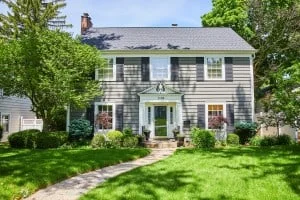 A two-story house with a pathway cutting through the grass leading up to the front door. A seller might want to know what it would be like selling this home to an iBuyer.